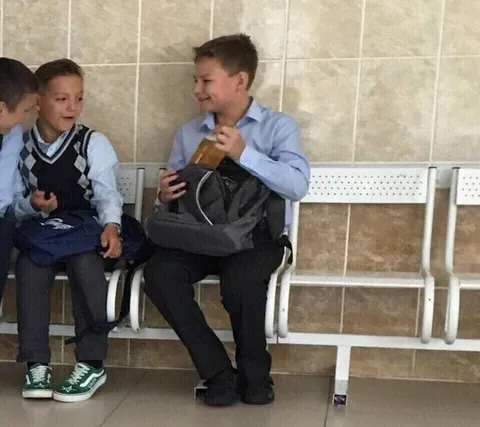 Мальчик прячет бутылку в рюкзаке