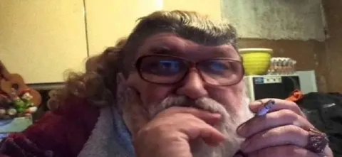 Мужчина задумчиво смотрит в камеру