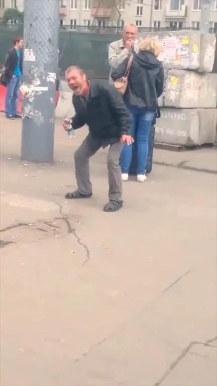 Мужчина истерично смеётся на улице