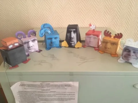 Странные бумажные персонажи на шкафу