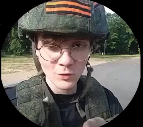Солдат в очках смотрит в камеру