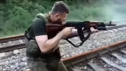 Боец стреляет на железной дороге
