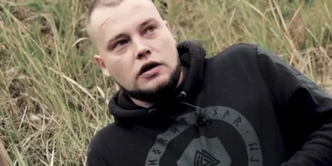 Мужчина в траве что-то объясняет