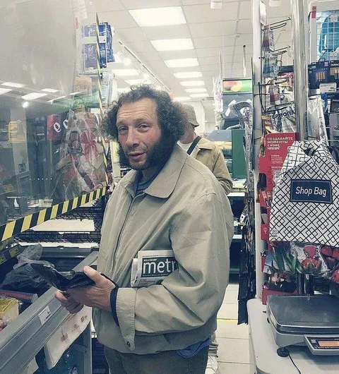 Мужчина с газетой в магазине