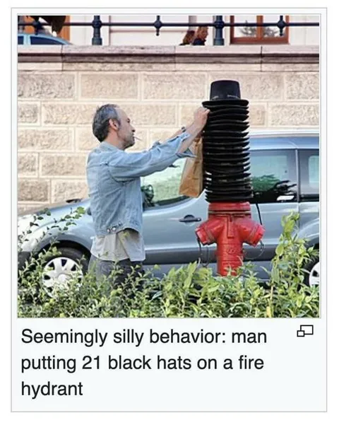 Man Stacks Hats on Fire Hydrant