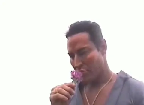 Мужчина нюхает цветок