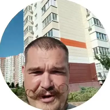 Усатый мужчина на фоне многоэтажек