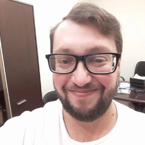 Улыбающийся мужчина в очках