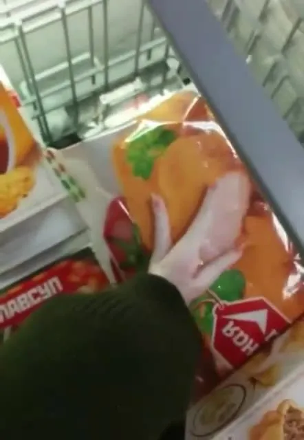 Рука выбирает продукты в магазине