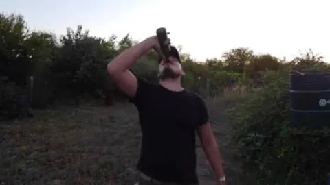 Мужчина выпивает на закате