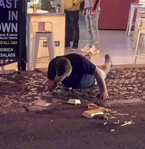 Man Crawling After Dropped Food