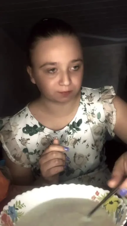 Женщина ест суп и хлеб