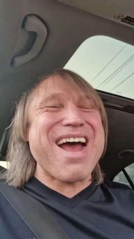 Мужчина смеётся в машине