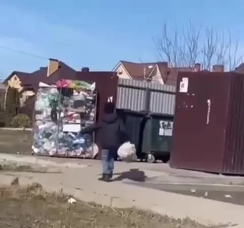 Мужчина прячется у мусорных баков