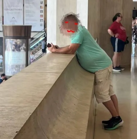 Мужчина прислонился к стойке