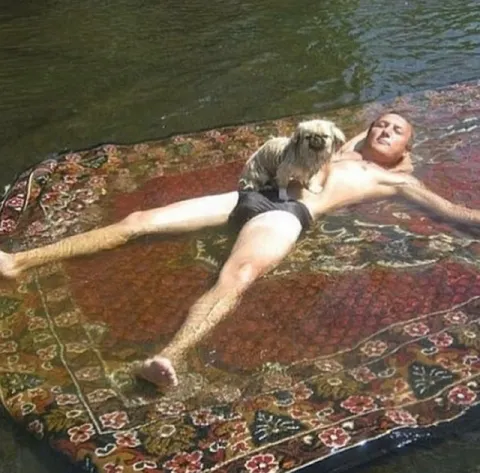 Мужчина отдыхает на ковре в воде