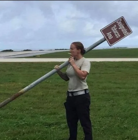Carrying the Tobacco Area Sign