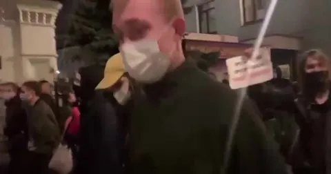 Мужчина проходит через толпу протестующих